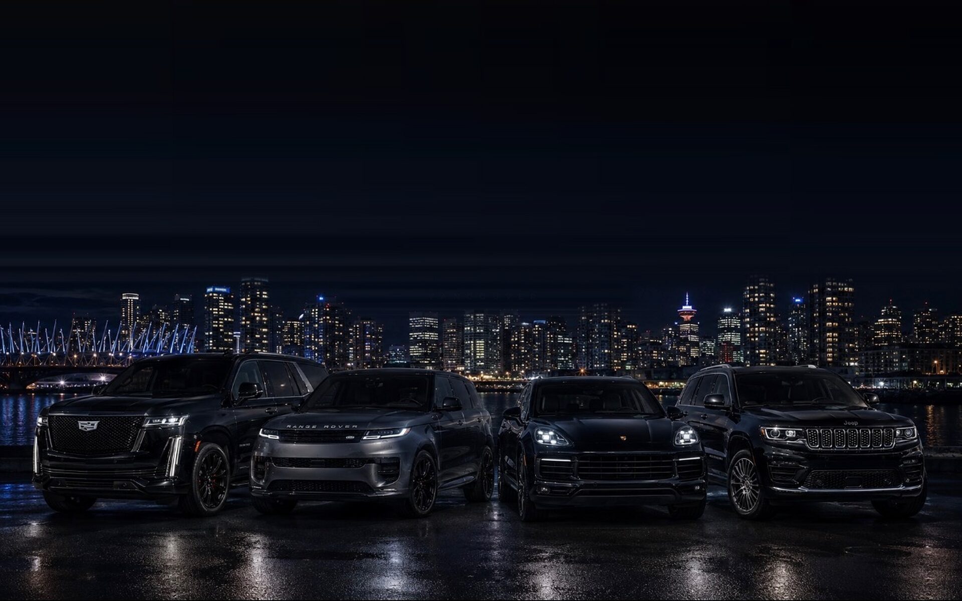 The DRVN Auto Rentals luxury SUV fleet at night in downtown Vancouver